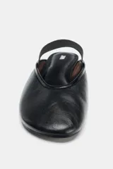 Bailarina plana destalonada de piel color negro, con escote redondo y una tira elástica ancha en el empeine para ajuste.