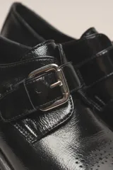 Zapato de cuero vacuno color borgoña con acabado charol, taco cuadrado de 4 cm y hebilla lateral.