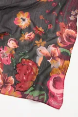 Pañuelo cuadrado con estampado floral sobre fondo oscuro, confeccionado en una mezcla de cupro y modal. Presenta aplicaciones de lentejuelas que resaltan los motivos botánicos en tonos rojos y rosados.