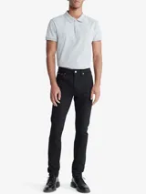 Chomba de manga corta color gris jaspeado, corte slim, con cuello polo y tapeta de tres botones. Presenta un pequeño logo monograma bordado en el pecho.