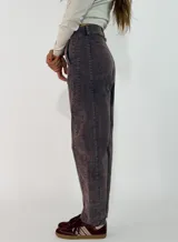 Pantalon de pana color marron oscuro, de corte recto y tiro medio, con costuras reforzadas en las rodillas y cierre frontal con boton.