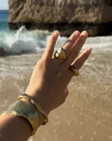 Brazalete rígido plateado con textura irregular.