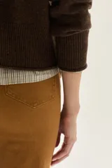 Cardigan de tejido de punto en color marrón, con cuello en V, cierre frontal de botones y detalle de bordado en una de las mangas.