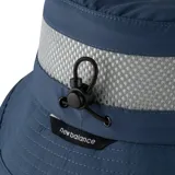 Gorro tipo bucket New Balance color azul, con una franja de malla gris en la parte superior y un parche rectangular negro con el logo de la marca en el frente.