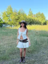 Top negro de tirantes finos con escote decorado con encaje y lazos frontales ajustables. Presenta una silueta liviana y femenina con diseño fluido.