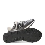 Championes urbanos New Balance modelo 574, color gris metalizado con detalles en beige y blanco. Presentan el logo N característico en los laterales, cordones al tono y entresuela con tecnología ENCAP para mayor amortiguación.