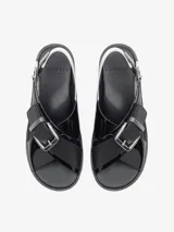Sandalia negra de tiras anchas cruzadas con hebillas metálicas y plataforma con suela de goma.