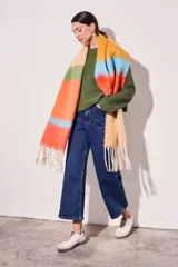Bufanda larga tejida a rayas horizontales en tonos naranja, celeste, amarillo y beige, con flecos en los extremos.