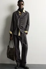 Blazer cruzado de corte relaxed fit, confeccionado en mezcla de lana de color marrón oscuro jaspeado. Presenta solapas de muesca, doble botonadura frontal multiposición y bolsillos con solapa en la cadera.