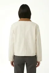 Campera de denim gris con efecto deslavado, cuello camisero de terciopelo negro, bolsillos frontales aplicados y cierre con botones metálicos.