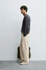 Pantalón chino de corte recto confeccionado en tejido ligero de algodón con estructura canvas. Presenta bolsillos frontales, bolsillos traseros de vivo y cierre frontal con cremallera y botón.