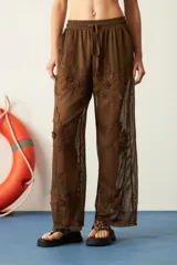 Pantalón blanco de red con bordado de flores y calce recto.