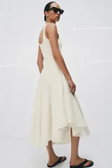 Vestido largo color blanco de algodón, con escote redondo, tirantes anchos y bajo asimétrico con godets.
