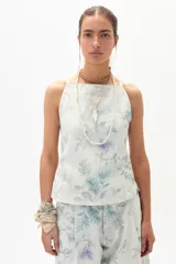 Top de denim con estampado floral en tonos celeste, lila y verde. Diseño ajustado con breteles finos.