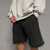 Short de algodón con efecto desgastado, corte baggy holgado, cintura elástica con cordón ajustable y bordes deshilachados.