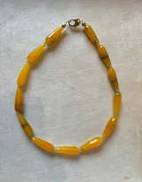 Collar de piedras naturales de ágata en formato alargado tipo gota, con tonos ámbar y amarillo miel, que presentan transparencias y vetas orgánicas.