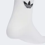 Pack de tres pares de medias Adidas de caña media, con diseño deportivo que incluye las tres bandas características y el logo del trébol bordado. El set incluye un par azul con bandas blancas y dos pares blancos con detalles de bandas en colores rojo, azul y negro.