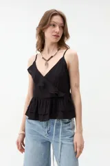 Musculosa blanca de tirantes finos, con escote en V cruzado y detalle de volados en el escote y en el ruedo con diseño de capas.