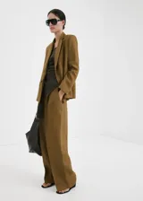 Pantalón de lino color verde militar, de corte recto y tiro bajo, con bolsillos laterales y trabillas para cinturón.