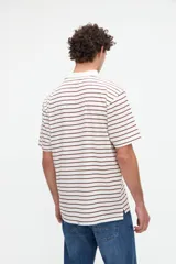 Remera polo de manga corta con diseño a rayas horizontales marrones sobre base blanca, cuello camisero en color blanco con media cartera de botones y aberturas laterales en el dobladillo.