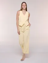 Pantalón sastrero color amarillo, de corte recto y largo al tobillo. Cuenta con cintura con presillas, fino cordón textil para anudar, bolsillos laterales y pinzas de entalle.