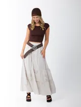 Falda larga de estilo campesino color crudo, confeccionada en algodón italiano con apliques florales al tono. Tiene cintura elastizada y cinto de rafia elastizado desmontable.