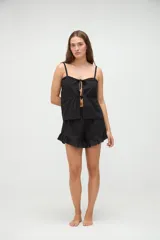 Short de pijama blanco con textura a rayas sutiles, cintura elástica con etiqueta de la marca y detalle de volados en el ruedo.