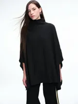 Poncho amplio de cuello alto, confeccionado en hilado con lana y cashmere, con diseño de caída recta y botones laterales.