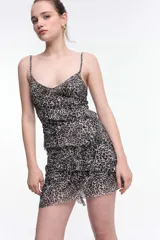 Vestido corto de tirantes finos con estampado de cebra en blanco y negro, escote en V y espalda baja. Presenta volados y frunces que realzan la figura.