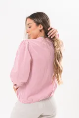 Camisa de manga larga con diseño a rayas rojas y blancas, cuello camisero y cierre frontal con solapa.