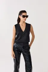 Chaleco tejido negro con lurex, escote en V y terminaciones de rib.