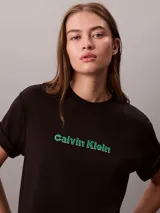 Remera Calvin Klein de manga corta y cuello redondo, color negro, con logo de la marca bordado en 3D en tono verde en el pecho. Presenta un corte regular y mangas con vuelta.