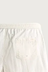 Short de baño en tejido técnico color beige claro, con cintura elástica ajustable con cordón y botón, bolsillos laterales y detalle de costuras en contraste.