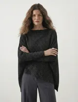 Poncho verde de tejido lurex, con cuello recto, manga japonesa con puños y terminación asimétrica.