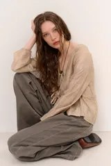 Chaqueta ligera de manga larga en tono beige, con escote en V y lazos frontales para atar.