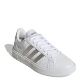 Championes urbanos Adidas modelo Grand Court Base 2.0, color blanco con las icónicas tres franjas laterales en tono gris metalizado. Presentan un diseño inspirado en los años 70 con suela tipo cupsole de caucho y cierre mediante cordones.