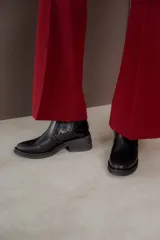 Bota corta de cuero marrón con panel trasero de gamuza en tono más oscuro, suela de goma negra y taco cuadrado bajo.