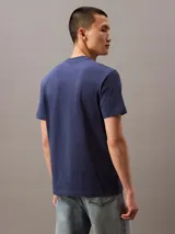 Remera azul de algodón con cuello redondo, mangas cortas y logo "Calvin Klein Jeans" estampado en el pecho.