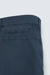 Bermuda de algodón color azul marino con efecto lavado, corte regular fit. Presenta bolsillos frontales de plastrón, bolsillo cerillero y bolsillo trasero de vivo. Cierre frontal con cremallera y botón.