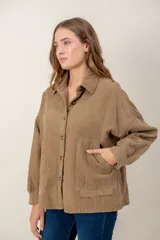 Campera de pana color tostado con diseño capitoneado en forma de rombos, cuello camisero, cierre frontal con botones y bolsillos delanteros.