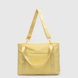 Bolso tipo tote color amarillo, con diseño funcional y espacioso. Cuenta con doble asa de mano y una correa larga ajustable y extraíble con el logo de la marca estampado. Incluye un bolsillo frontal con cierre y compartimento interno para computadora portátil.