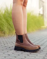 Botinetas estilo Chelsea de cuero marrón, con paneles laterales elásticos en color negro y suela track dentada de goma negra.