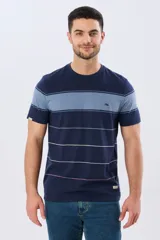 Remera de algodón con diseño de rayas horizontales en tonos azul marino, celeste y líneas finas en verde claro y amarillo pálido. Cuenta con cuello redondo y mangas cortas, con un pequeño bordado en el pecho.