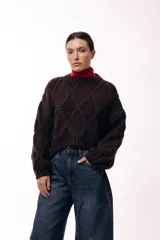Sweater de tejido de punto grueso con diseño de rombos en relieve, cuello redondo y mangas largas amplias. Presenta una silueta relajada y holgada.