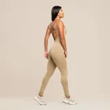 Jumpsuit color beige de poliamida biodegradable, con tirantes finos, escote cuadrado y escote en la espalda. Diseño ajustado, sin costura frontal y forro frontal y trasero en la parte inferior para evitar transparencias.