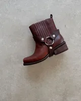 Bota de cuero negra, desmontable 3 en 1, con detalle de arnés con aros metálicos y hebillas.