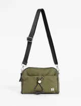Bandolera color verde militar, confeccionada en material waterproof. Cuenta con doble cierre en el compartimento principal, un bolsillo frontal con cierre y cordón ajustable con stopper, y un bolsillo trasero con cierre. Incluye correa larga regulable de color negro.