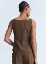 Chaleco de corte recto y diseño sin mangas, confeccionado en algodón. Presenta cuello escotado, cierre frontal con botones y dos bolsillos de ribete en la parte delantera.