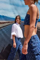 Pantalón de jean azul denim con tiro bajo, corte oversize y grabado láser con monograma.