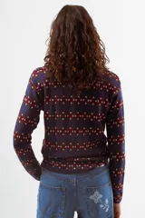 Camiseta de manga larga con cuello polo y cierre frontal parcial, confeccionada en tejido de punto con estampado geométrico en tonos azul, bordó y celeste.